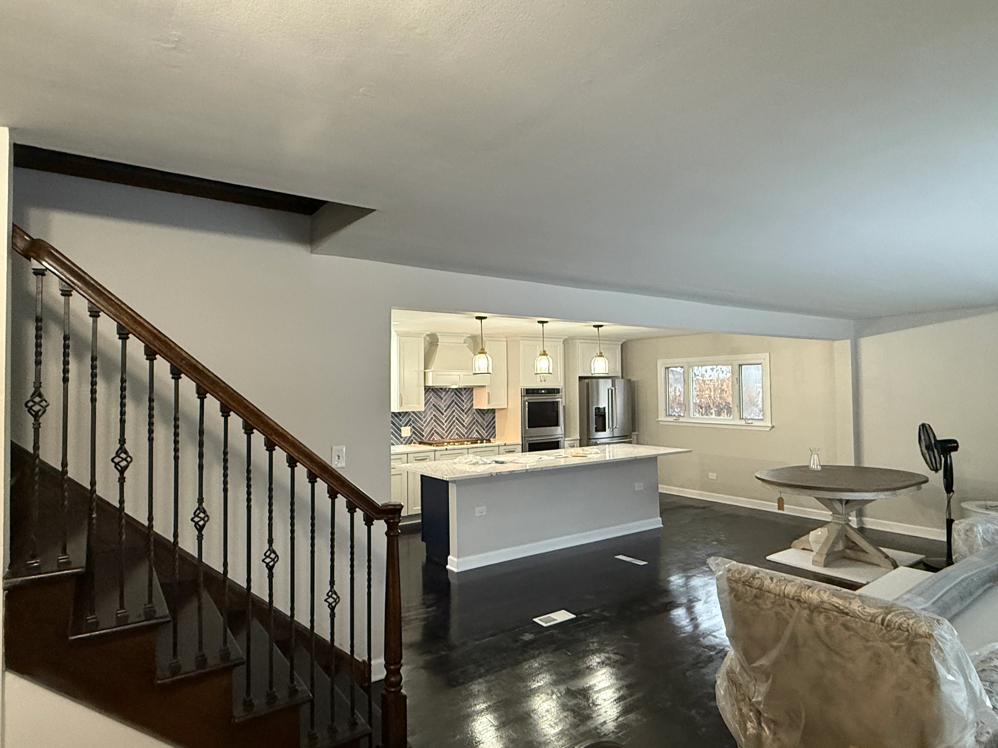 Open concept kitchen with cream cabinets, island, and dark hardwood floors