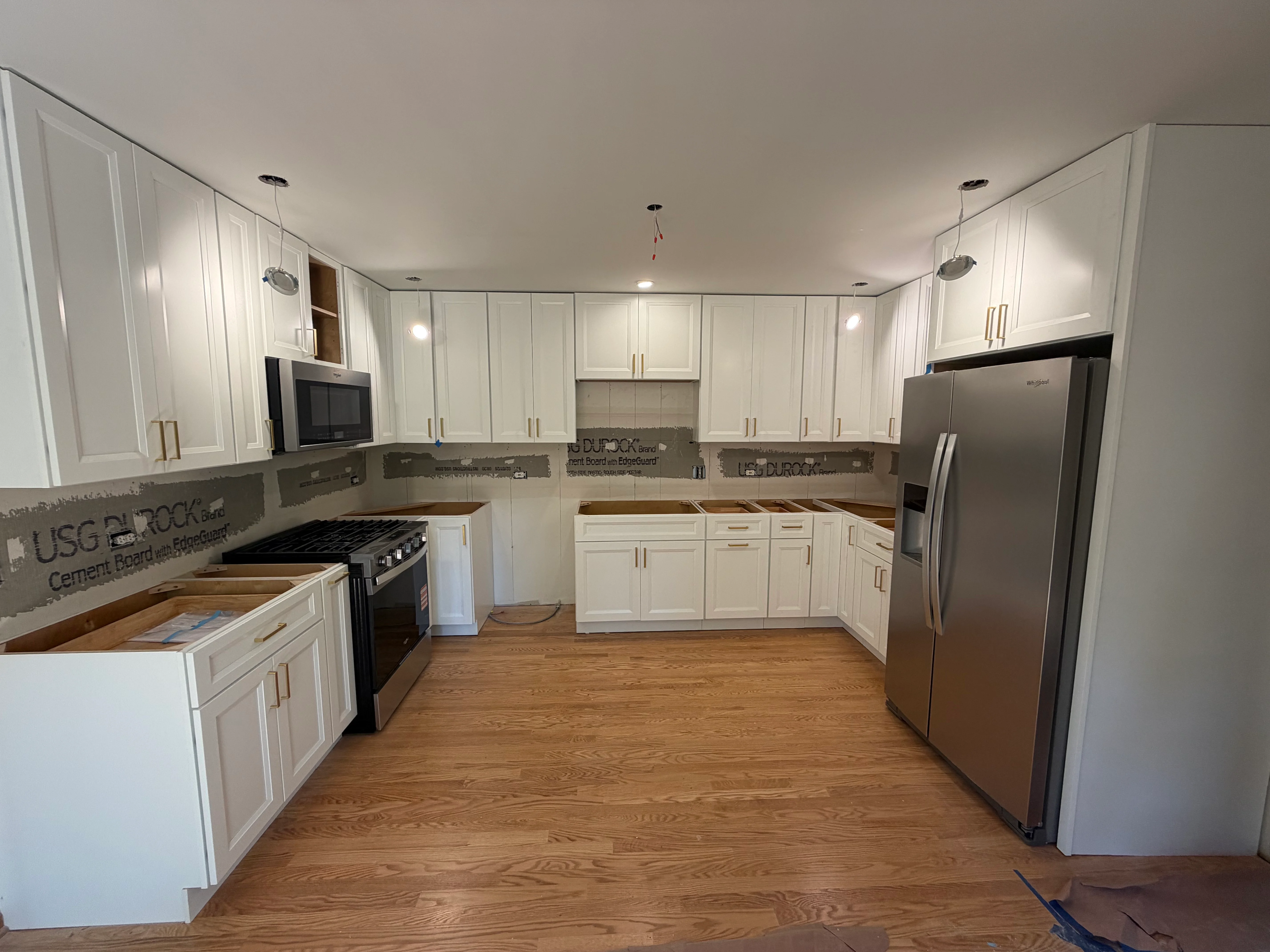 Modern kitchen with white cabinetry, stainless steel appliances, and hardwood floors