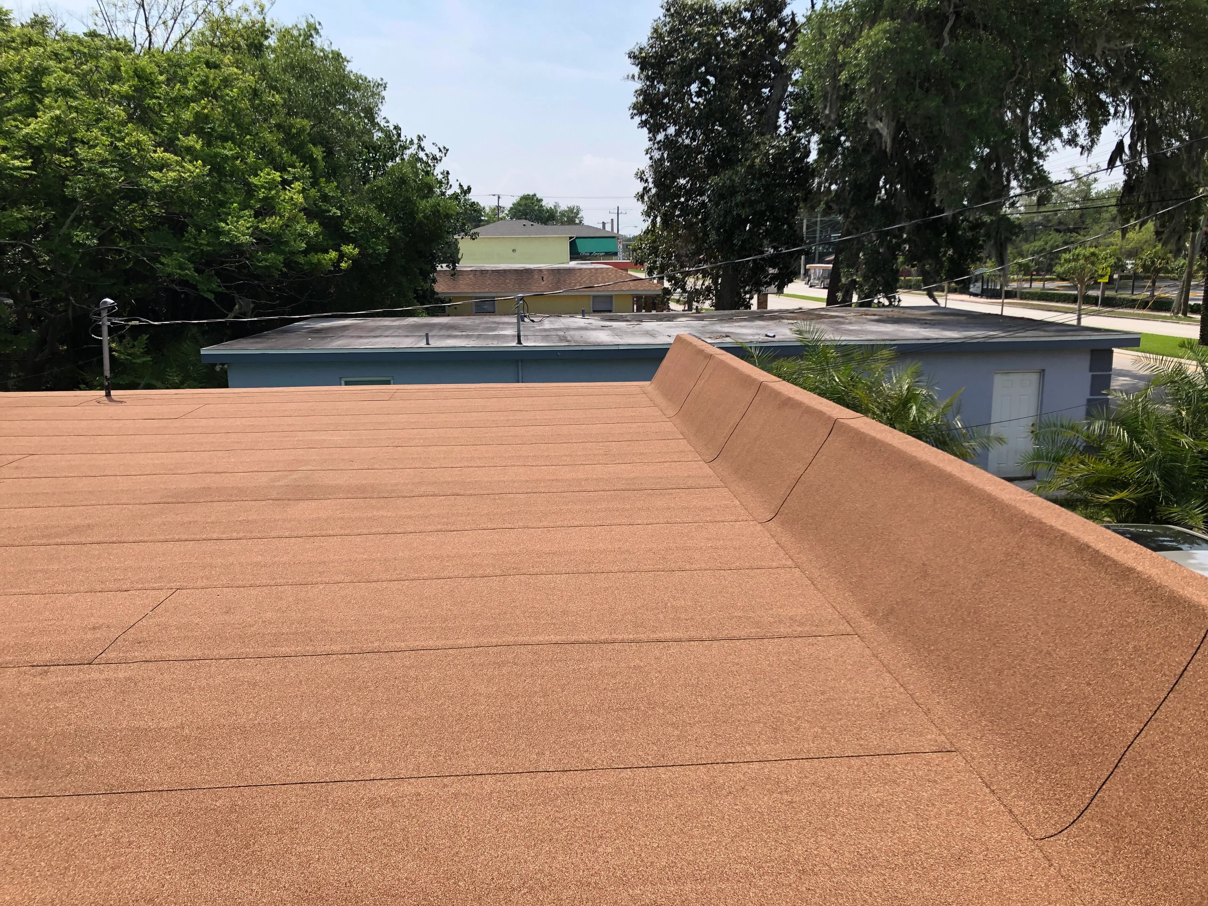 Cork-colored composite deck with cable railing overlooking commercial pool facility